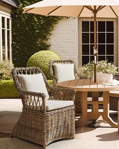 an outdoor table with two chairs and an umbrella