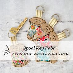 two key fobs with flowers on them and the words spool key fobs