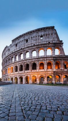 the colossion in rome is lit up at night, with its lights on