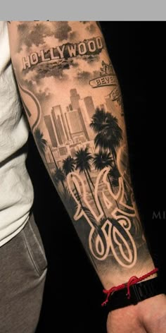 a man with a tattoo on his arm that says hollywood and palm trees in the background