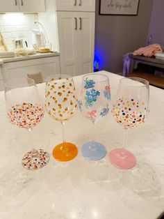 four wine glasses sitting on top of a kitchen counter