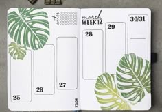 an open planner with green leaves on it