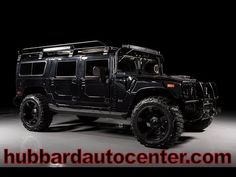 a black hummer truck parked in a dark room