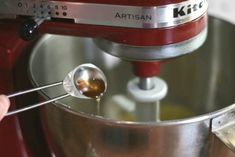 a person is mixing something in a bowl with a spoon and a whisk