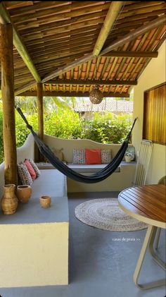 a hammock sitting on top of a patio next to a table