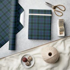 a table topped with green plaid wrapping paper next to scissors and other crafting supplies