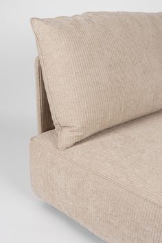 a beige couch with two pillows on top of it