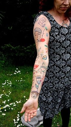 a woman with tattoos on her arm holding a frisbee