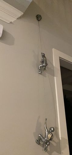 three silver figurines hanging from the ceiling