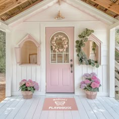 a pink front door with two potted flowers on the porch and a welcome mat