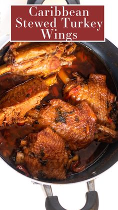 a pan filled with cooked turkey wings on top of a white stovetop next to a red sign that says, carib bean stew turkey wings