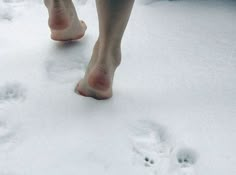 two people walking in the snow with bare feet