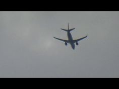 an airplane is flying in the sky on a cloudy day