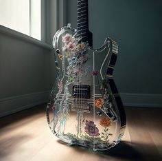 an electric guitar with flowers on it sitting in the middle of a room next to a window