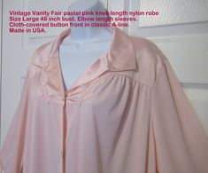 "Size Large, in a pretty pastel pink nylon, this vintage Vanity Fair robe features their traditional A-line knee length style with five cloth-covered front buttons. Made in the USA, it has a fold-down collar, small floral appliques on the yoke, three quarter length sleeves and one hidden side pocket. As can be seen in the photos, the classic VF floral small applique trim is on the yoke. In addition, satin-look nylon nylon is used for the collar and the cuffs of the sleeves in the robe. Please us Statement Scarf, Fabric Labels, Rose Pastel, Vintage Vanity, Womens Robes, Pretty Pastel, Elbow Length Sleeve, Vanity Fair, Side Pocket