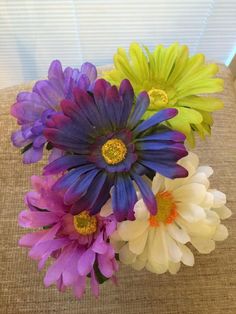 a bunch of colorful flowers sitting on top of a couch