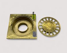 a gold plate with a circular hole in the middle and a small piece of metal next to it