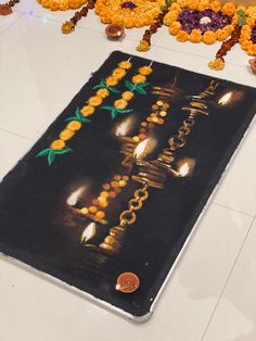 a black mat with candles on it in front of flowers and garlands around it