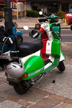 two mopeds are parked on the side of the road next to each other