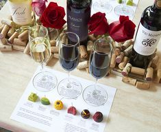 three wine glasses with different wines in them on a table next to some corks