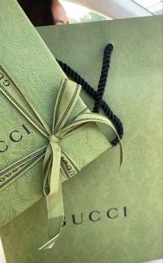 an open gucci book with a ribbon tied around it