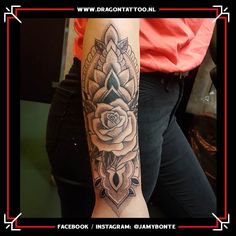 a woman's arm with a rose and diamond tattoo design on it, in black and white