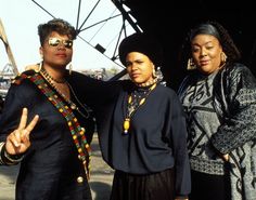 three women standing next to each other posing for the camera