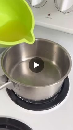 someone is using a yellow strainer to stir the pan on top of the stove