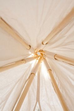 the inside of an umbrella with wooden poles