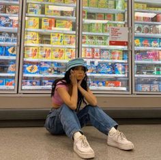 a woman sitting on the ground in front of a store