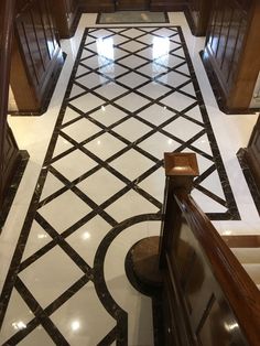 an ornate tiled hallway with wooden doors and brown cupboards on either side, leading up to the second floor