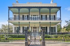 a large white house with black iron fence