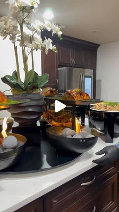 a kitchen counter topped with lots of plates and bowls filled with food on top of it