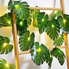 a ladder is decorated with green leaves and lights