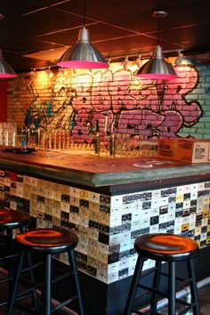 an image of a bar with stools and graffiti on the wall in the background