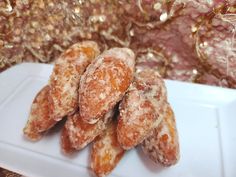 some sugared donuts are on a white plate