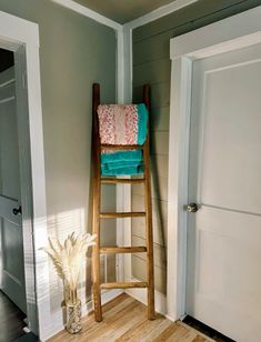 a wooden ladder with towels on it next to a door