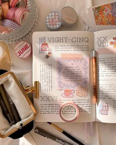 an open book sitting on top of a table filled with crafting supplies and other items