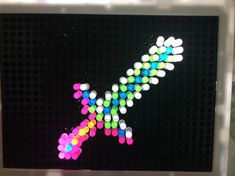 a close up of a sign with many colored dots on the letter k in front of it