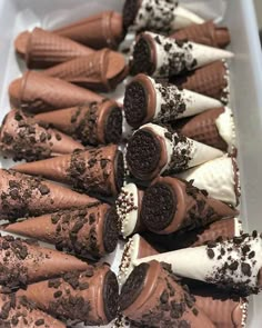 chocolate ice cream cones with oreo cookies and sprinkles on them in a white tray