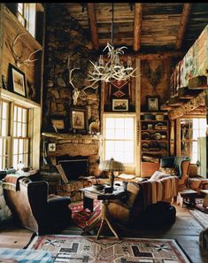 a living room filled with furniture and a chandelier hanging from the ceiling over a fire place