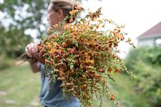 a woman holding a bunch of flowers in her hands