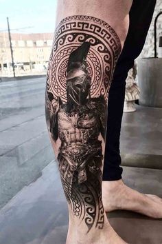 a man's leg with a tattoo on it and an image of a warrior