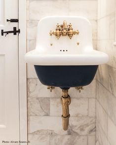 a white and blue sink sitting on top of a marble counter next to a door