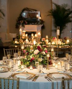 the table is set with candles, flowers and wine glasses for an elegant wedding reception