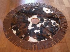 a cow print rug is on the floor next to a wooden table with scissors in it