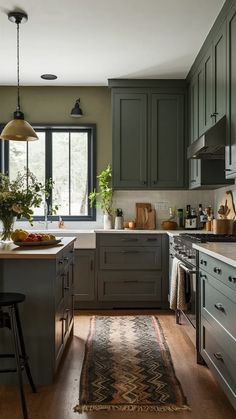 a kitchen with green cabinets and an area rug