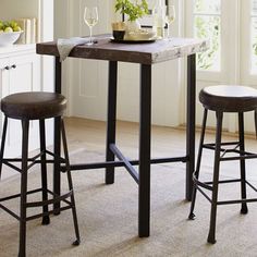 a kitchen table with two stools next to it