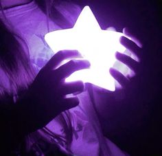 a person holding a glowing star in their hands