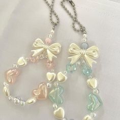 two necklaces with hearts and bows on them